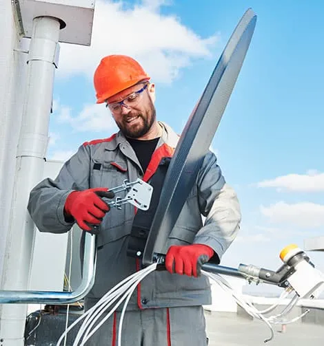 Technicien antenniste réglant une antenne TV